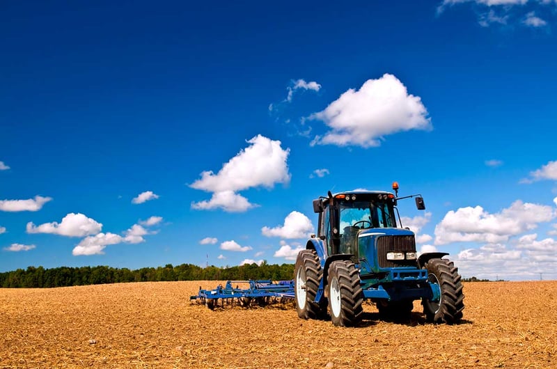 Traktor jedzie po polu latem