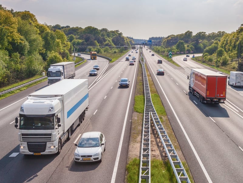 Samochody i ciężarówki jadą autostradą w dwie strony