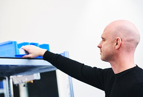 Bufab-a-man-placing-an-empty-bin-on-shelf